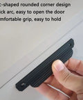Hand holding black cabinet pull showing arc design, part of Black Cabinet Pulls 4 Pack for Kitchen Cabinets and Drawers 4.72 Inch Length.