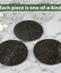 Three black marble discs on marble surface, illustrating material of Marble 16 Inch Lazy Susan Turntable Organizer For Cabinets Pantries Kitchen Counters Fridge And Vanity With Silent Smooth Rotation Anti Slip Rubber Feet And Durable Aluminum Bearing For Easy 360 Degree Access Black.