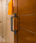 Sliding Barn Door Handles Set In Black 7.4 Inch gate handles visible on wooden door in interior bathroom setting