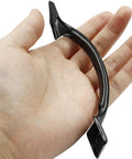 Close-up of a matte black door handle from 4 Pack 6 Inch Bow Style Metal Door Handles Door Pulls For Furniture Cabinets Kitchen Drawers Dressers Gates Vintage Barn Door Hardware Matte Black Durable Rustproof Iron Ideal For Heavy Doors And Frequent Use, shown in hand for scale.