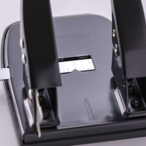 Close-up of black Two Hole Paper Punch 30 Sheet Capacity Black For Office And School With Adjustable Guide And Easy Chip Tray