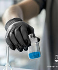 Person wearing Black Nitrile Disposable Gloves 4.5 Mil Powder Free Latex Free Food Safe Exam, holding a container in a lab.