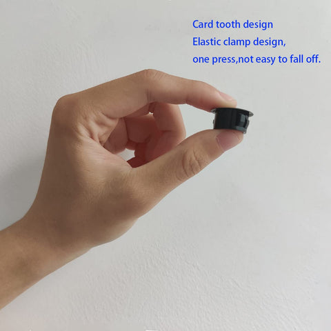 Hand holding a black plastic hole plug, 12 Pack Black Plastic Hole Plugs For Cabinet And Screw Holes, 25mm Size Fits 24.5 To 25mm Openings