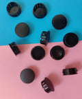 12 Pack Black Plastic Hole Plugs For Cabinet And Screw Holes, 25mm Size Fits 24.5 To 25mm Openings scattered on colored surface