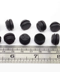 Black SBR rubber push-in bumpers, 1/2 inch diameter, 1/8 inch height, next to ruler, pack of six, surface protection, withstands -20 to 180°F.