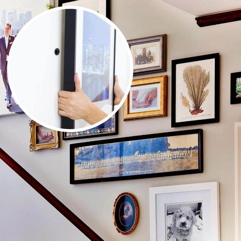 Person hanging a picture frame on a wall using 140pcs Black Self Drilling Drywall Anchors Kit with #8 Flat Head Screws