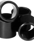 Stack of black bearing spacers for skateboard and longboard, set of 4, designed to help precise wheel alignment and smooth rolling.