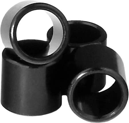Stack of black bearing spacers for skateboard and longboard, set of 4, designed to help precise wheel alignment and smooth rolling.