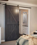7ft Barn Door Hardware Kit with I shape hanger installed in bedroom doorway, featuring black sliding door track and heavy duty carbon steel.