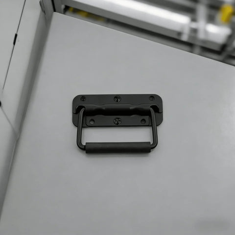 Installed view of spring loaded chest handle with rubber grip on metal surface