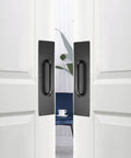 Two Piece 16 Inch Stainless Steel Door Handle Pull And Push Plate Set in brushed black installed on wooden doors in an office space.