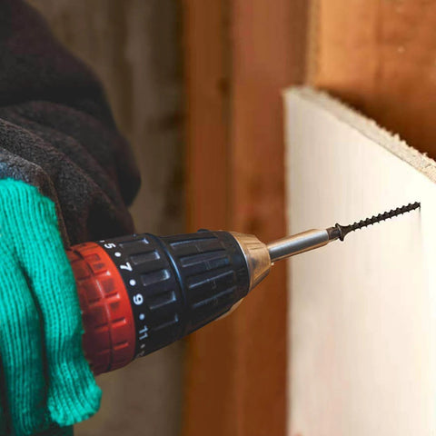 Hand using drill with #8 x 3/4 Inch Black Phosphate Stainless Steel Wood Screws into drywall