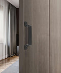 Sliding Barn Door Handle Black Steel, 7.5 Inch Length, installed on a wooden door in a modern interior