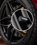 Close-up of 4 Piece Black Anodized Aluminum Plastic Composite Tire Valve Stem Caps With Integrated Plastic Sleeve on car wheel