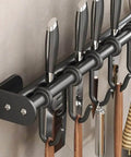 Close-up of Modern Kitchen Utensil Rack, Black Wall-Mounted Hanging Rod with 6 Movable Hooks holding kitchen tools.