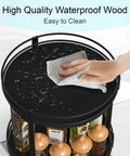 Two Tier Wooden Lazy Susan Spice Rack With 360 Degree Rotation, black finish, showing a hand wiping the waterproof surface.