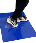 Person stepping on blue Adhesive Sticky Floor Mats 24 By 36 Inches For Construction Sites Labs Cleanrooms Hospitals And Sports Shoes