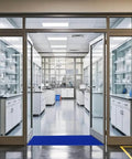 Blue adhesive sticky floor mat 24 by 36 inches installed at lab entrance, traps dirt in high traffic areas, 12 pack for construction sites, cleanrooms.