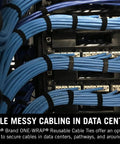Image of One Wrap Tape For Cable Management Double Sided Reusable Cable Organizer For Installers And Contractors Secure Hold Easy To Install Half Inch By Twenty Five Yard Roll used on blue cables in a data center.