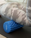 Person using High Density Foam Roller Massager with 3D Textured Rollers for leg muscle massage on yoga mat