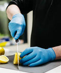 Person cutting lemon wearing Blue Nitrile Gloves 3 Mil Textured Large Latex Free Powder Free Box Of 100
