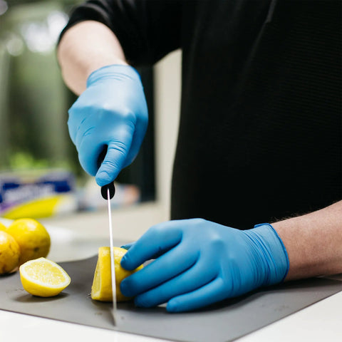 Person wearing Blue Nitrile Gloves 3 Mil Textured Large Latex Free Powder Free Box Of 100 cutting lemon