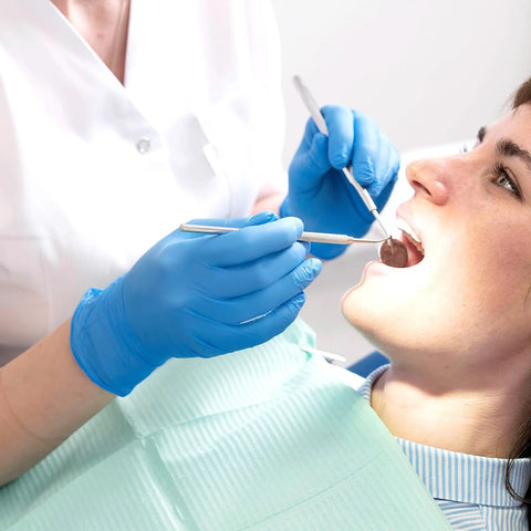 Dentist wearing Blue Nitrile Exam Gloves Medical Grade Size M 1000 Count Latex Free Disposable while examining a patient