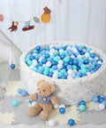 Ball pit with blue and white plastic play balls for kids, featuring a teddy bear and decorative background. Phthalate Free BPA Free 100pcs.