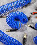 Six Pack 25 Foot Polyurethane Recoil Air Hose With One Quarter Inch Quick Connect And Plug Bend Restrictor Anti Twist Coil Line For Home Garage Or Workshop Blue on concrete floor with tools