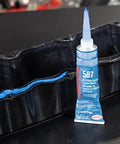 Auto Grade RTV Silicone Gasket Maker Blue 587 Pro Grade High Temp Oil Resistant Sensor Safe Non Corrosive Flexible Sealant For Engine Gaskets And Vehicle Repairs 80 Ml 1 Pack shown next to an engine gasket