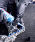 Person applying Auto Grade RTV Silicone Gasket Maker Blue 587 Pro Grade High Temp Oil Resistant Sensor Safe Non Corrosive Flexible Sealant