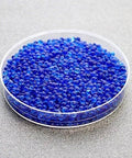 Clear dish of Blue Indicating Silica Gel Beads 3 To 5 Mm Desiccants Reusable Moisture Absorbers For Storage And Electronics on gray surface