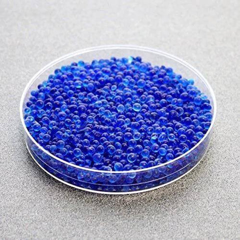 Clear dish of Blue Indicating Silica Gel Beads 3 To 5 Mm Desiccants Reusable Moisture Absorbers For Storage And Electronics on gray surface