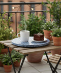 12.6 inch mother of pearl lazy susan turntable with blue starburst design, decorative rotating tray on a balcony table.