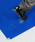 Foot stepping on blue Cleanroom Sticky Mat For Dirt And Dust Capture In Hospitals And Labs, 24 By 36 Inches, adhesive tacky mat.