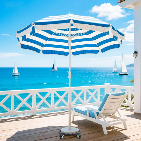 Striped beach umbrella with lounge chair on deck overlooking ocean and sailboats