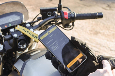 Rider using Bluetooth app to control Essentials Micro XSystem 3.0 Plus Electronic Automatic Motorcycle Chain Lubrication System
