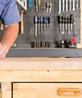 Person using Fixed Base Router 2.25 HP 12 Amp Variable Speed 8000 to 25000 RPM for precise edge work on wooden surface