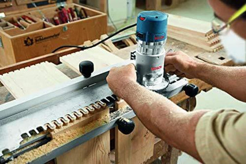 Person using Bosch 1617EVS Fixed Base Router 2.25 HP 12 Amp Variable Speed 8000 to 25000 RPM for precise edge work on wood.