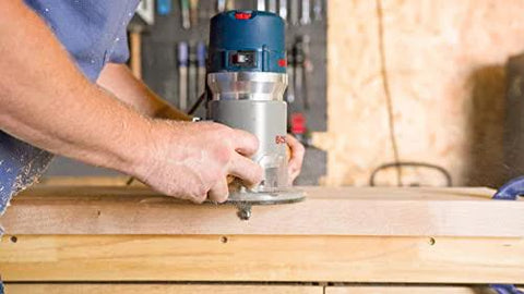 Person using Bosch 1617EVS fixed base router 2.25 HP 12 Amp variable speed 8000 to 25000 RPM for precise edge work and mortising on wood