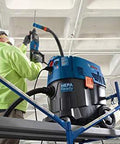 Worker using One And One Eighth Inch SDS-Plus Bulldog Xtreme Max Rotary Hammer for drilling overhead concrete on scaffold.