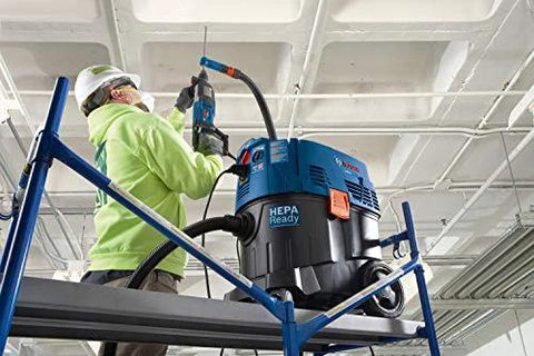 Worker using One And One Eighth Inch SDS-Plus Bulldog Xtreme Max Rotary Hammer for drilling overhead concrete on scaffold.