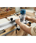 Person using Fixed Base Router 2.25 HP 12 Amp Variable Speed 8000 to 25000 RPM for precise edge work and mortising on wood.