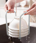 Hands holding 2 Pcs Bowl Rack for Kitchen Cutlery, Retractable Plastic Dish Rack with stacked bowls under running water