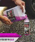 Person pouring Brake Buster Wheel Cleaner With Non Acid Formula For Safe Use On All Wheels Removes Brake Dust Dirt And Corrosion into a bottle