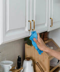 Person cleaning white cabinets with Six Pack Antique Brass Cabinet Pulls With 3 3/4 Inch Center To Center, Aged Bronze Drawer Handles