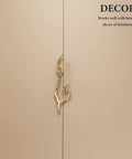 Close-up of Brass Flower Branch Cabinet Handle 5.91 Inch Blossom Drawer Pull Knob on beige cupboard door.