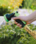 Hand using durable brass garden hose quick connect fittings 3/4 GHT quick coupler with sprinkler in outdoor setting