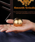 Golden solid hand therapy brass ball for hand exercise, meditation, and stress relief shown on a person's palm.