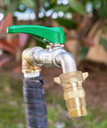 Brass RV Water Pressure Regulator With Filter Screen for campers and travel trailers, installed on hose, 40-50 PSI regulation.